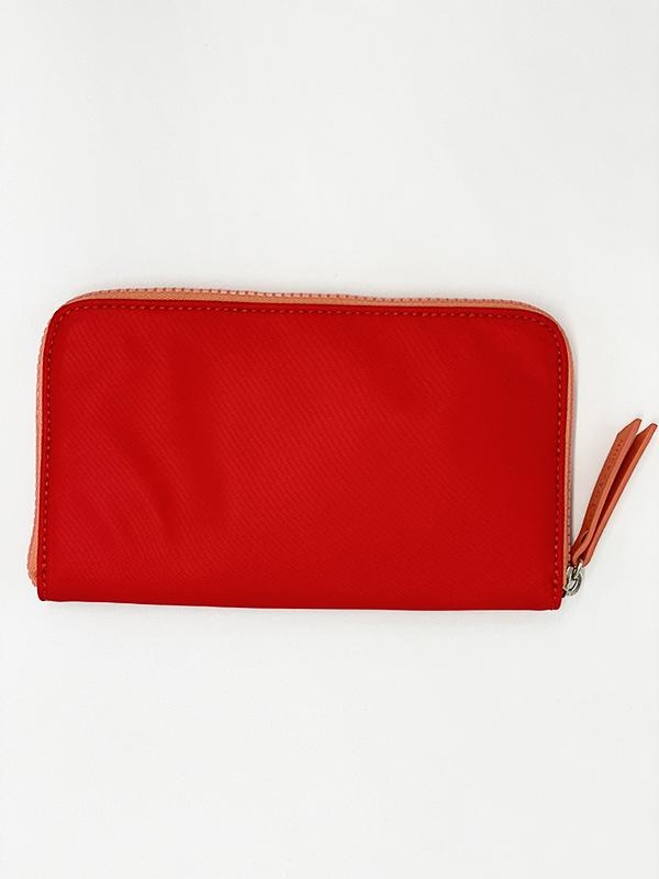 A red and coral water resistant wallet that has a lot of space for cards and notes, completed with a chunky YKK zipper.