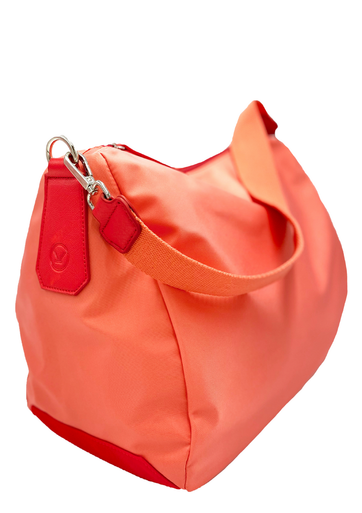A sporty red and coral lightweight handbag made of waterproof nylon and faux leather with internal pockets and shoulder straps.