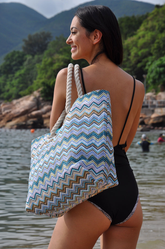 Women in swimwear holding a beautiful MAKARON beach bag