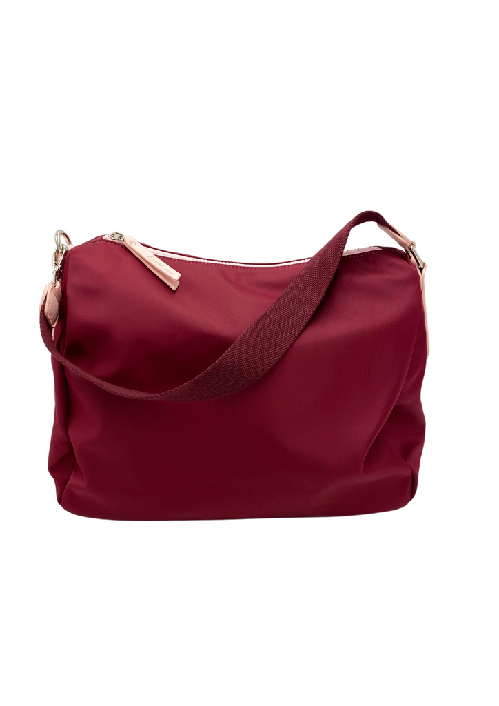 A sporty plum and pink lightweight handbag made of waterproof nylon and faux leather with internal pockets and shoulder straps.