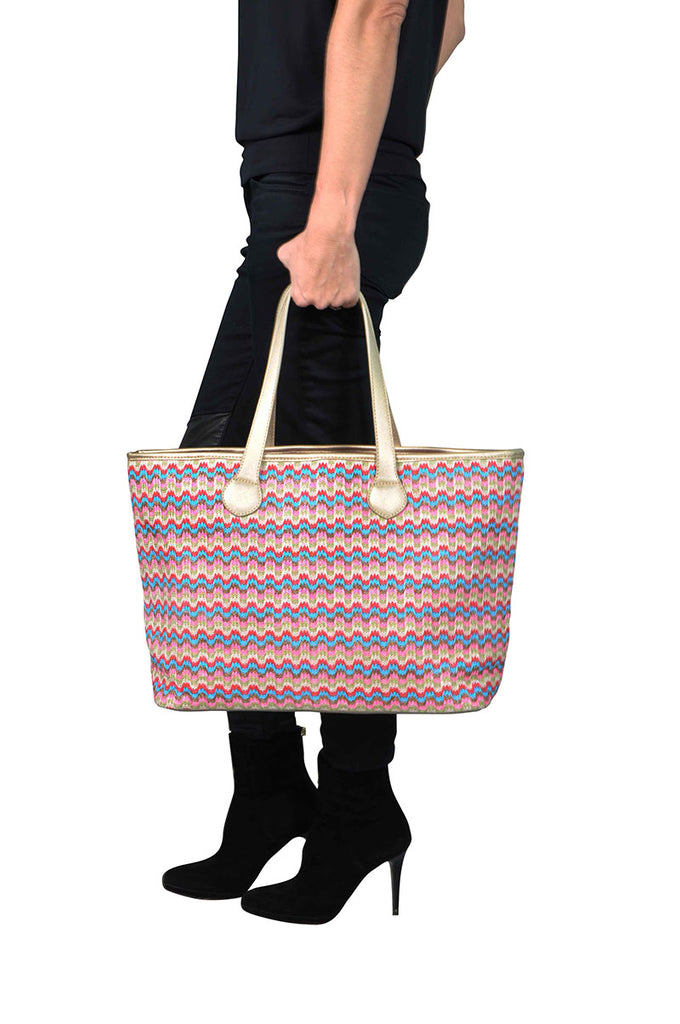 woman wearing a pink and gold travel tote bag